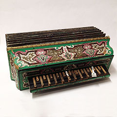Wooden accordion. The side is painted and decorated with green, pink, white and golden patterns.