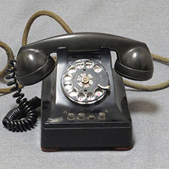 Bakelite telephone made of metal and plastic, circa 1935. It is a 3-line phone.