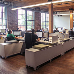 Bureaux de travail modernes où quelques employés travaillent derrière des ordinateurs.